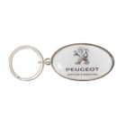 Oval keychain with a silver ring, featuring the Peugeot logo. The logo shows a lion standing on its hind legs, and below, the text reads PEUGEOT and MOTION & EMOTION.