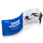 A man in a suit walks near a large curved advertisement with a blue section displaying Snowboarding Winter Ski Resort text, and a white section featuring images of two people skiing against a mountainous backdrop.