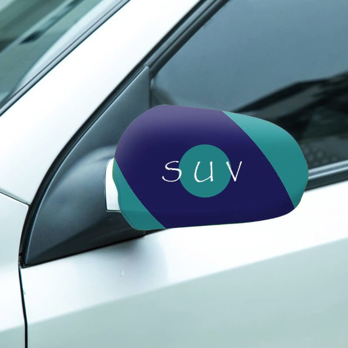 Close-up of a cars side mirror with a custom cover featuring a blue and teal design and the letters SUV in white. The cars exterior is a light color, possibly beige or silver.