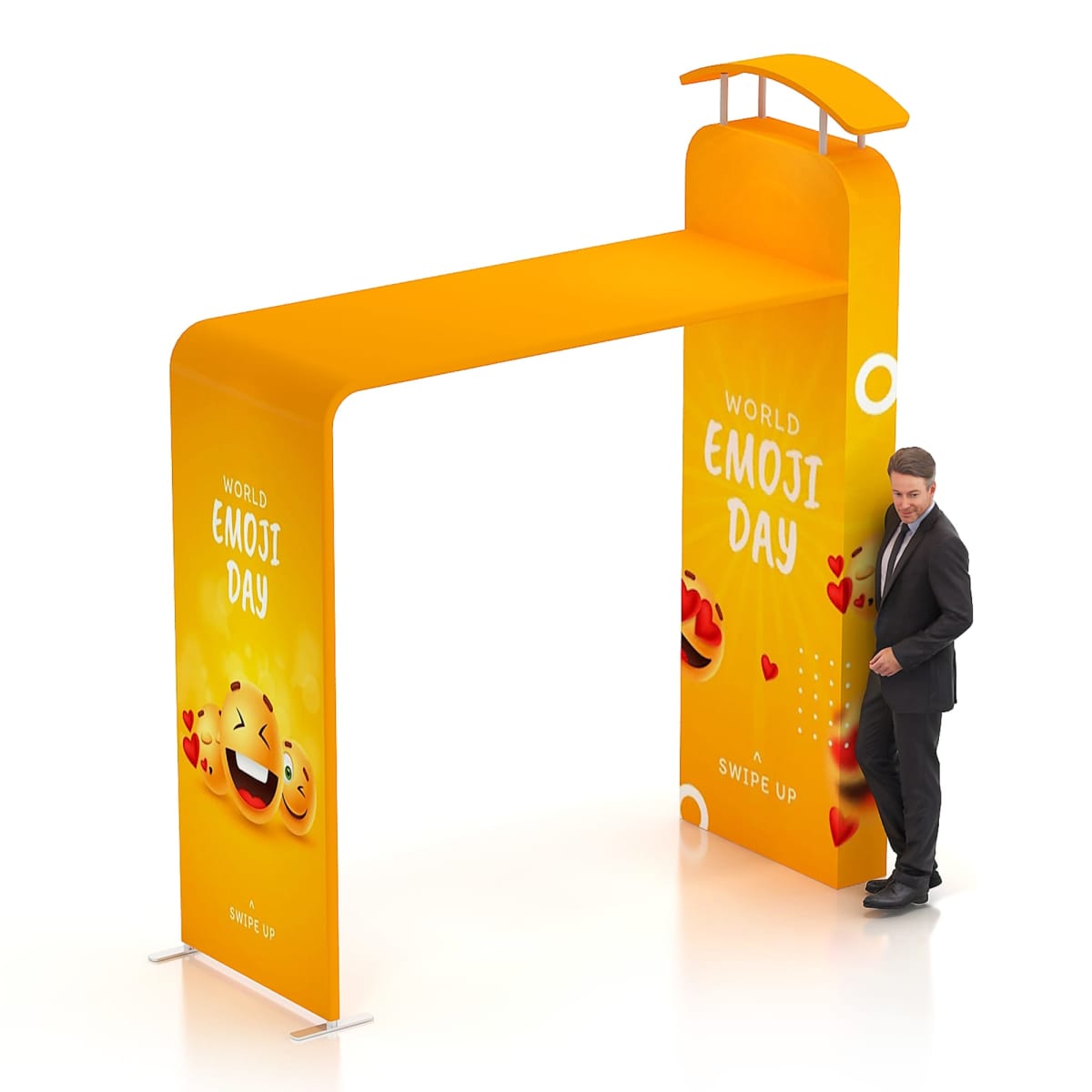 A man in a suit stands next to a large, orange promotional archway that reads World Emoji Day. The arch is decorated with smiling emojis and heart symbols.