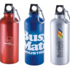 Three metal water bottles with carabiner clips. The first is red with a Templist technologies logo, the second is blue with Busy Mate Industries text, and the third is silver featuring the Burdekin Shire Council emblem with colorful flame design.