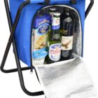 A blue insulated cooler bag on a folding black metal stand, open to reveal bottles and snacks, including Peroni beer and Lavash crackers. The coolers silver insulated lining is visible on the open flap.