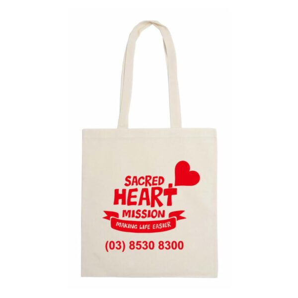 Beige tote bag with red text and graphics. Sacred Heart Mission is printed with a heart shape above. Below, a ribbon with the words Making Life Easier and a phone number (03) 8530 8300 are displayed.