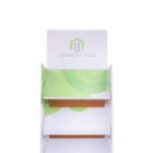 Empty white and green cardboard display stand with two shelves. Placeholder text Corporate Name and Slogan Goes Here are printed on the top background. The stand is designed for promotional or store use.