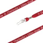 Red lanyard with white text saying Charlevilles 100th Show and a small paw print design. The lanyard includes a metal clip for attachment.