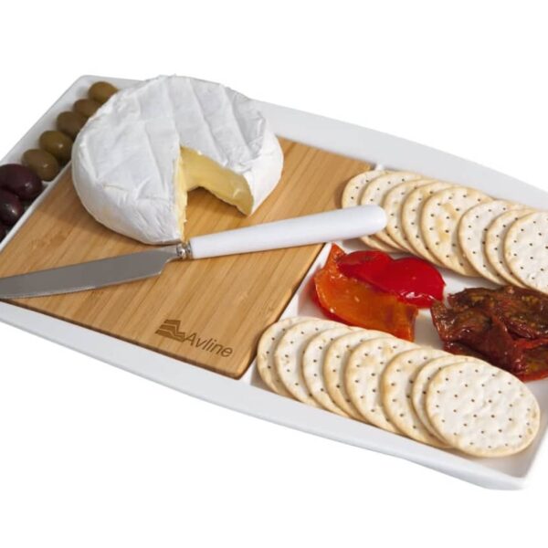 A platter featuring a round of soft cheese with a cut wedge, a cheese knife, an array of crackers, sliced red and orange bell peppers, dried tomatoes, and green and black olives. The items are neatly arranged on a wooden board.