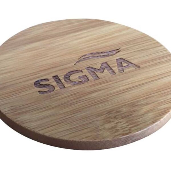 A round wooden coaster with the word SIGMA and a decorative design etched on its surface. The wood grain is visible, adding a natural texture to the coaster.