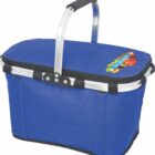 A blue insulated picnic basket with a black handle and a colorful text logo on the lid, featuring fruits. The basket has a sturdy metal frame and a zippered top.