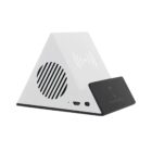A white triangular wireless charging stand with a built-in speaker. It has a black base and a USB port. The surface is minimalist and angled for easy device placement.