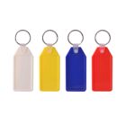 Four blank key tags in white, yellow, blue, and red are lined up against a white background. Each tag features a metal key ring attached at the top.