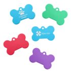 Five colorful bone-shaped dog tags are displayed: a blue one with COMPANY NAME, a green one, another blue with DOG TOY, a red one, and a purple one. They each have a small hole for attachment.