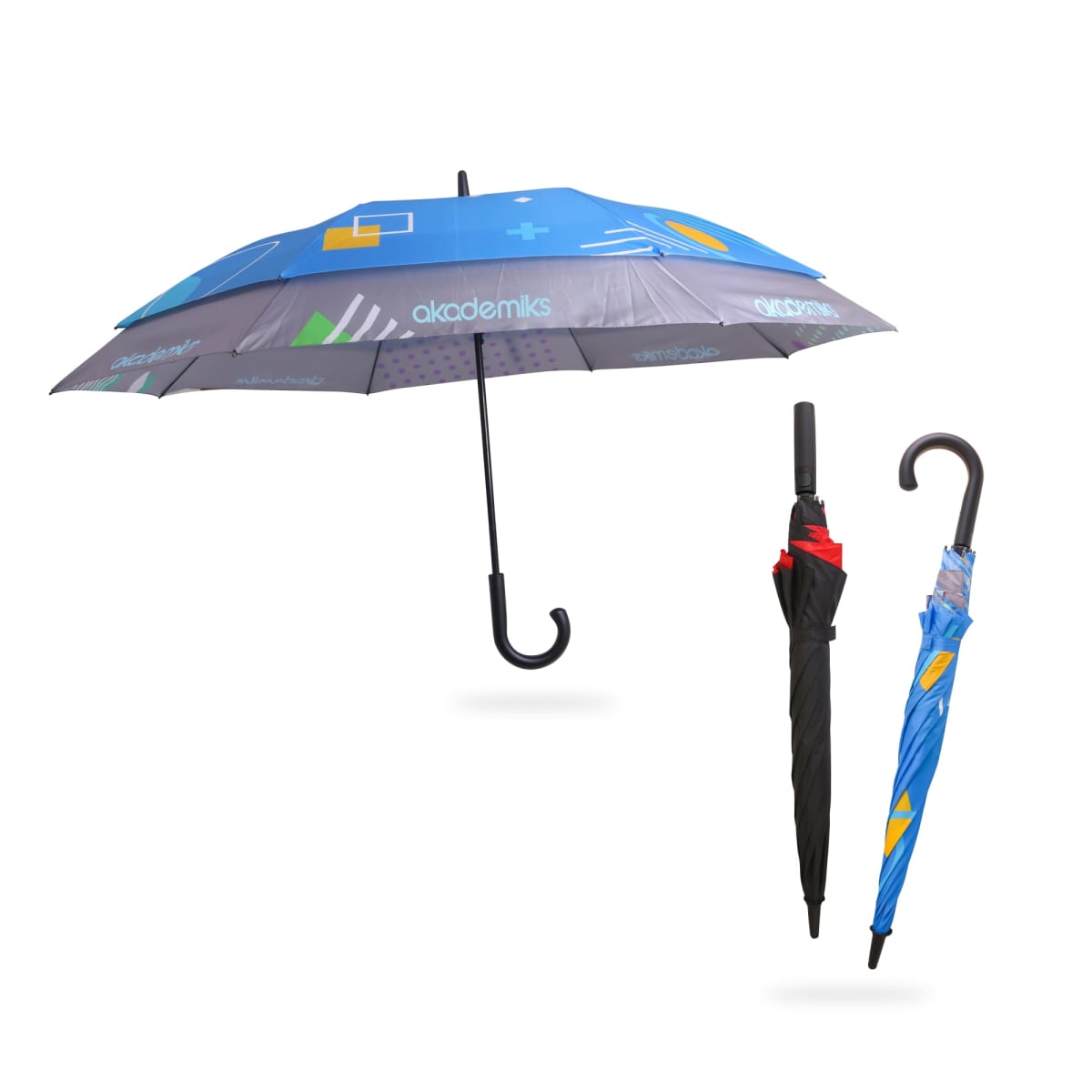 Three umbrellas are shown. One is open, revealing a blue canopy with geometric patterns and branding. The other two are closed: one is black with a red strap, and the other is blue with similar patterns. They have curved black handles.