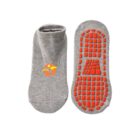 A pair of gray no-show socks. The sock on the left displays a small, colorful logo with an abstract bird design. The bottom of the right sock features a pattern of orange rubber grips for traction.