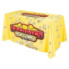 Yellow tablecloth with a pattern of popcorn and a large logo reading Freddies Popcorn Company. The logo features red and white text with popcorn graphics above and below.