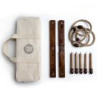 A ring toss game set including a beige carrying bag, two wooden boards with point markers, a rope ring with wooden beads, and five wooden dowels with handles, arranged neatly on a white background.