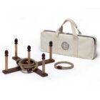 A wooden ring toss game set with a cross-shaped base and five pegs, along with rope rings for tossing. The set includes a beige carrying bag for easy transport.
