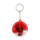 Round keychain with a red and white design featuring a portrait of a person wearing a red hat. Text reads, Hope 2023 Engr. Sen. Rabiu Musa Kwankwaso.