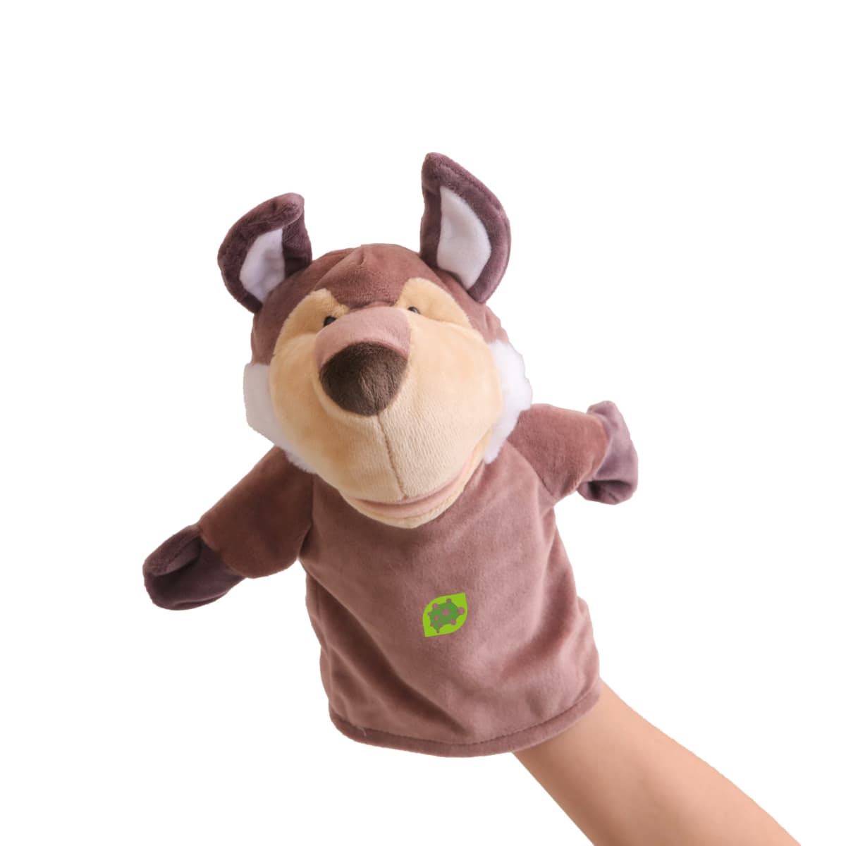 A hand is inside a brown wolf puppet with white accents on its face and ears. The puppet has a cartoonish expression and a green recycling symbol on its chest. The background is white.