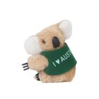 A small, plush koala toy holds a fork in one paw and wears a green jacket with I ♥ AUSTRA printed on it. The koala is light brown with white ears and a black nose, shown against a plain white background.
