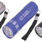 Three LED flashlights in silver, blue, and black. Each flashlight features a keychain strap and the text C-LINK AGENCY with a logo on the side. Theyre arranged in a row on a white background.
