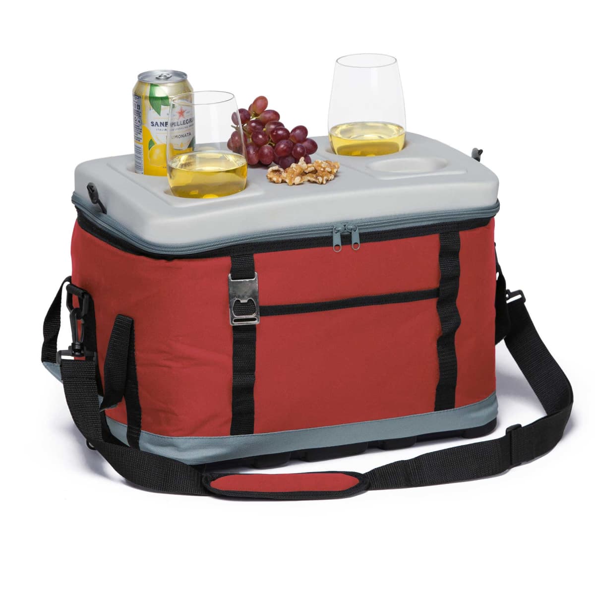 A red cooler bag with a gray lid is shown. On top, there are two glasses of white wine, a can of San Pellegrino, a bunch of grapes, and a few walnuts. The bag has a shoulder strap and front pocket.
