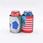Two canned drinks in colorful koozies. The left can is in a soccer-themed holder with a blue and white ball on green. The right can is in a red, white, and blue striped holder with text PARTAY DAYS and wavy patterns.
