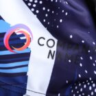 Abstract design on fabric with blue, white, and black shapes, featuring a multicolored circular logo next to the text COMPANY NAME in black letters.