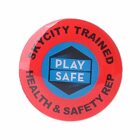 A circular red badge with a blue hexagon in the center. The hexagon reads PLAY SAFE in white letters. The outer ring reads SKYCITY TRAINED HEALTH & SAFETY REP in black text.