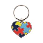 A heart-shaped keychain made of colorful interlocking puzzle pieces in blue, red, yellow, and light blue. It is attached to a metal ring.