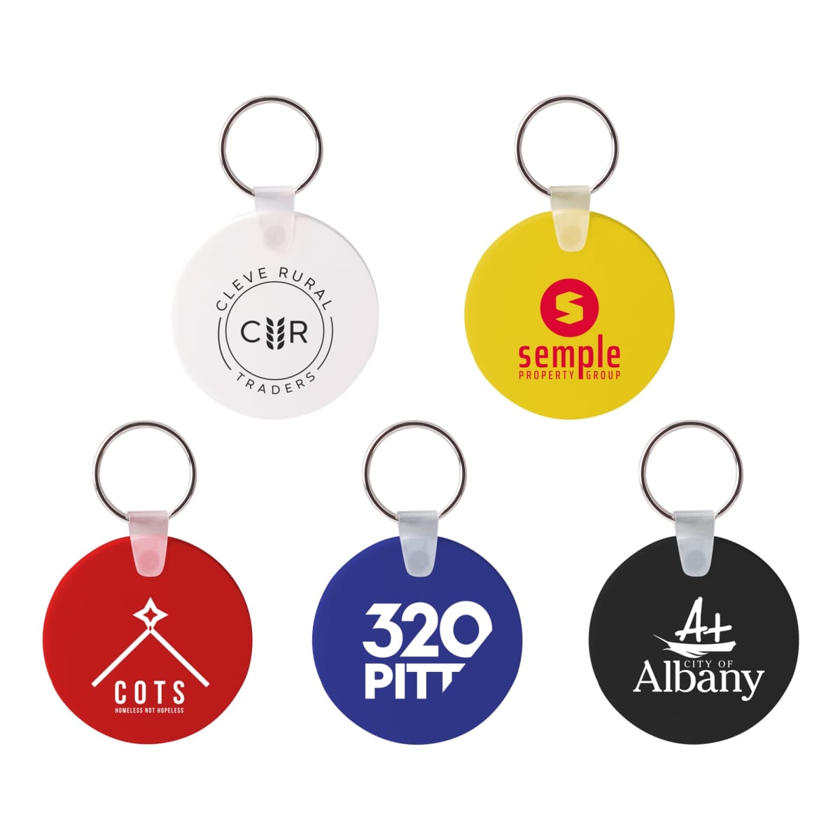 Five round keychains with logos: a white one with Cleve Rural Traders, a yellow one with Semple Property Group, a red one with COTS, a blue one with 320 Pitt, and a black one with City of Albany.
