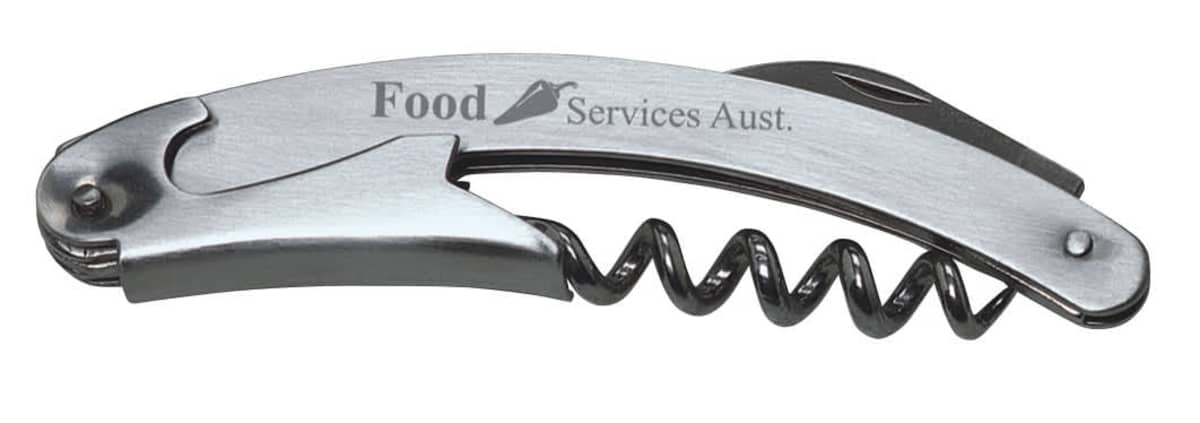 A metallic corkscrew with a foil cutter and a lever. The text Food Services Aust. is printed on the handle.