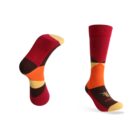 Two colorful socks featuring a geometric pattern with red, orange, yellow, and brown sections. One sock is upright, while the other is positioned to showcase the sole.