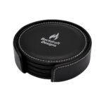 A set of round, black leather coasters with white stitching, stacked neatly in a matching holder. The top coaster is embossed with a flame logo and the text Backdraft Designs.