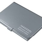 A sleek, silver metal business card holder is closed, with Kirin Nord Heavy Manufacturing engraved on the top.