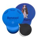 Two blue round gel packs, one labeled Benexol and the other with a dog image and text Puppies. The packs are slightly different shades of blue and have a small black backing visible from behind.
