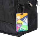 A black travel bag with a colorful luggage tag attached. The tag displays various brand logos including JBL, AKG, Martin, DigiTech, Studer, AMX, Soundcraft, and Crown against a vibrant background.