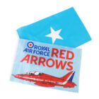 A blue flag with a white star lies next to a poster featuring a red aircraft and the text Royal Air Force Red Arrows.