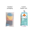 Two pairs of socks are displayed. One is in standard transparent packaging, revealing a colorful sock. The other is in a custom header card packaging with a winter design featuring snowflakes and a bear wearing sunglasses.