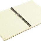 Open spiral-bound notebook with lined pages, lying flat at an angle. The pages are blank, and the notebook has a beige tone.