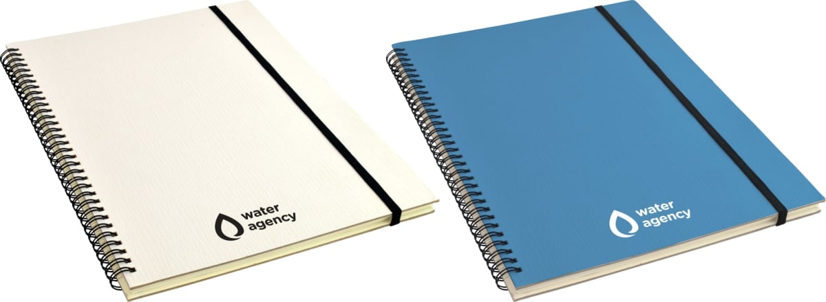 Two spiral-bound notebooks are shown, one with a white cover and the other with a blue cover. Both feature a water agency logo in the bottom right corner and have elastic bands to keep them closed.