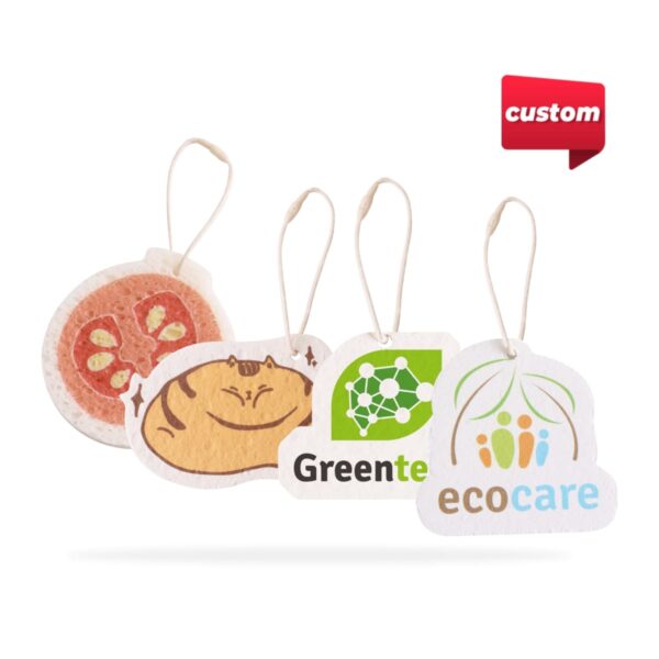 Four custom car air fresheners with string loops. Designs include a tomato slice, a cat, a network graphic with Greente text, and a logo with ecocare. A red custom tag appears in the top right.
