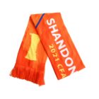 An orange scarf with fringes, featuring the text SHANDON 2021 CFA and a yellow trophy design.