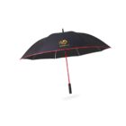 A black umbrella with a red handle and trim, featuring the Autoplus logo printed in yellow and white on one panel. The handle is straight with a black grip. The umbrella is open against a plain white background.