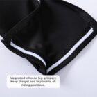 Close-up of black cycling shorts with white and black silicone leg grippers visible on the inner side. A caption reads, Upgraded silicone leg grippers keep the gel pad in place in all riding positions.