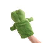 A green plush frog puppet is worn on a persons hand. The puppets simple design features basic shapes for the head and arms. The background is plain white, highlighting the texture and color of the puppet.