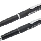 Close-up of two black pens with Helix Capital branding in white. One pen is a ballpoint with its tip extended, and the other features a stylus tip. Both pens have silver accents and clips.
