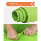 Close-up of a green yoga mat, rolled up and with a persons hands pulling at the mats edges. Text above reads Resistant to tearing and twisting with an arrow design.