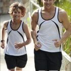Two people jogging outdoors, wearing matching black and white athletic tank tops and shorts. The background features greenery and a blurred path, with the text Bocini and Sports visible in the image.
