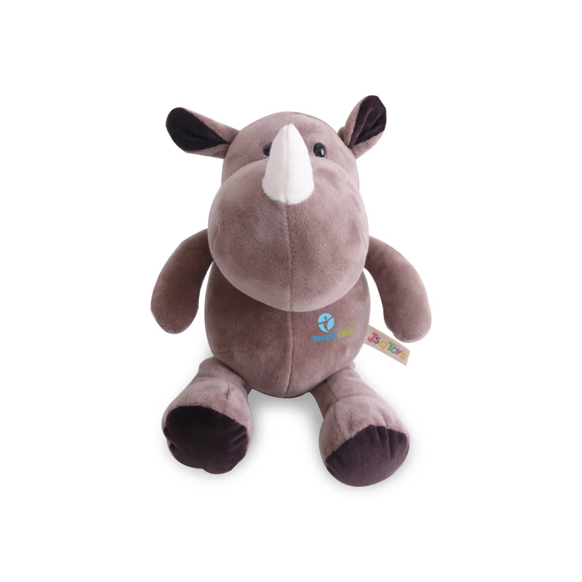 A plush toy rhinoceros with brown body and dark brown ears, hands, and feet. It has a white horn and embroidered patches with logos on one side of its chest and a fabric tag attached to its side.