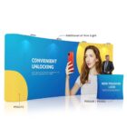 A trade show display features a large backdrop with a woman holding a red smartphone against a blue and yellow background. Text reads CONVENIENT UNLOCKING. A small counter in front displays NEW POLISHED LOOK. Spotlights are positioned above.